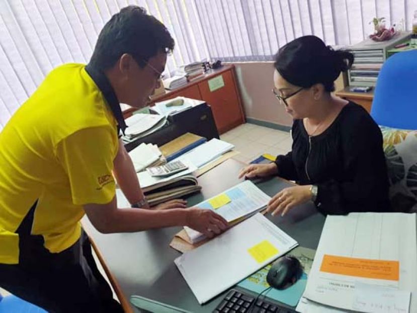陈开将新用户申请表格呈交给古晋水务局水表申请部经理克里斯蒂娜。
