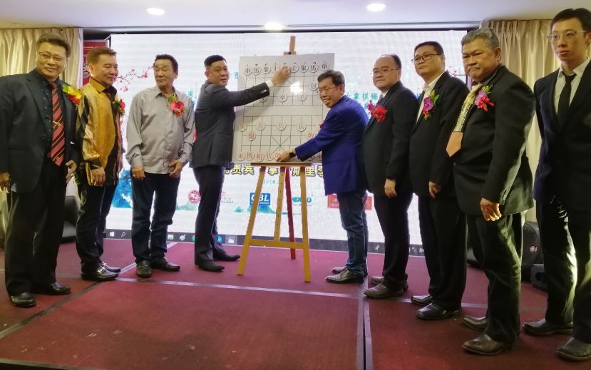 砂象棋联合会永久名誉会长拿督李祈龙（左四）及砂地方政府及房屋部长拿督沈桂贤（右五）主持开棋礼时摄，右起为象棋国际大师郑义霖、砂象棋联合会副会长贝丘镇江、砂象棋联合会主席曾令威、会长甲必丹拿督刘思乐；左起为筹委会主席沈象文、古晋象棋公会名誉主席刘泩、古晋象棋公会名誉会长黄张金发。