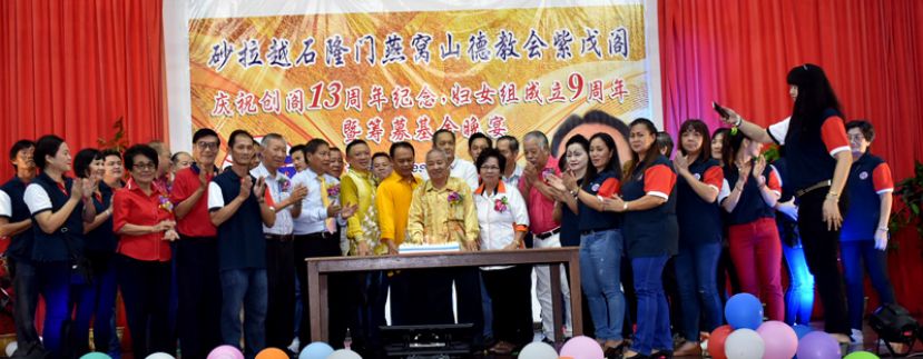 石隆门燕窝山德教会紫戊阁创阁13周年晚宴上，碧湖州议员拿督亨利（中）与众嘉宾理事共切纪念蛋糕。