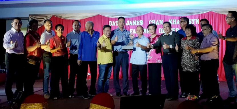 古晋南市贩商公会主席陈春雄（左8）在拿督沈桂贤（左7）等人见证下赠送纪念品予卸任南市市长拿督曾长青，前排右4为新任市长拿督黄鸿圣。