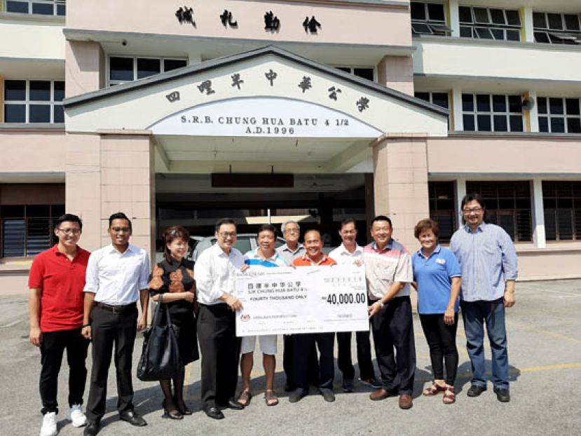 贸消部副部长张健仁(左四)移交支票给四哩半中华公学，由主席邓民权(右五)接收。左起;为张健仁特别助理沈杰龙、阿都阿兹、朋岭区州议员杨薇讳、副主席陈志文、副总务覃礼周、秘书官有源、副财政林耿鸿、总务余悦凤及监学刘祯水。