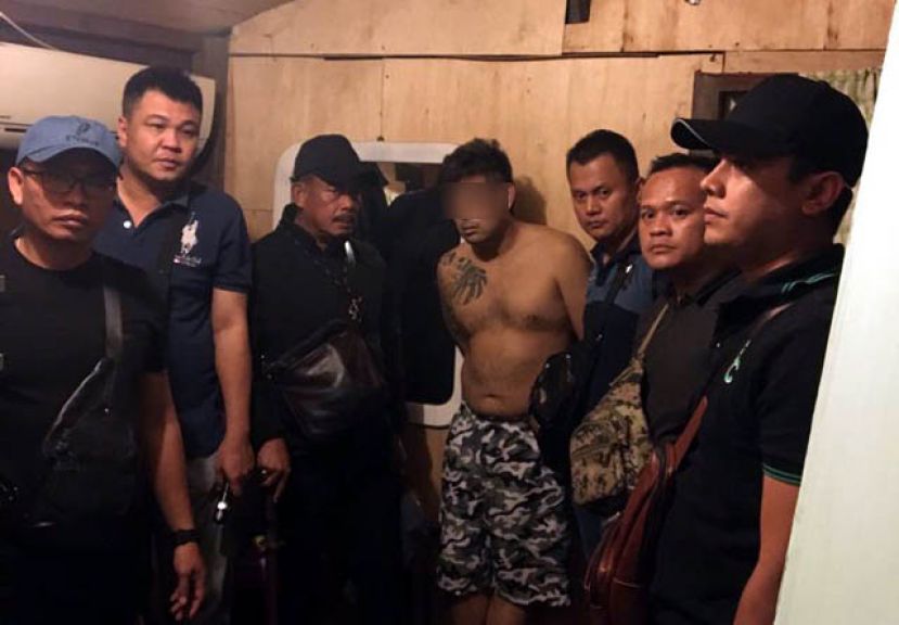 美里警方成功逮捕悍匪&ldquo;肥狗&rdquo;，准备将赤膊上身的嫌犯押返警局。