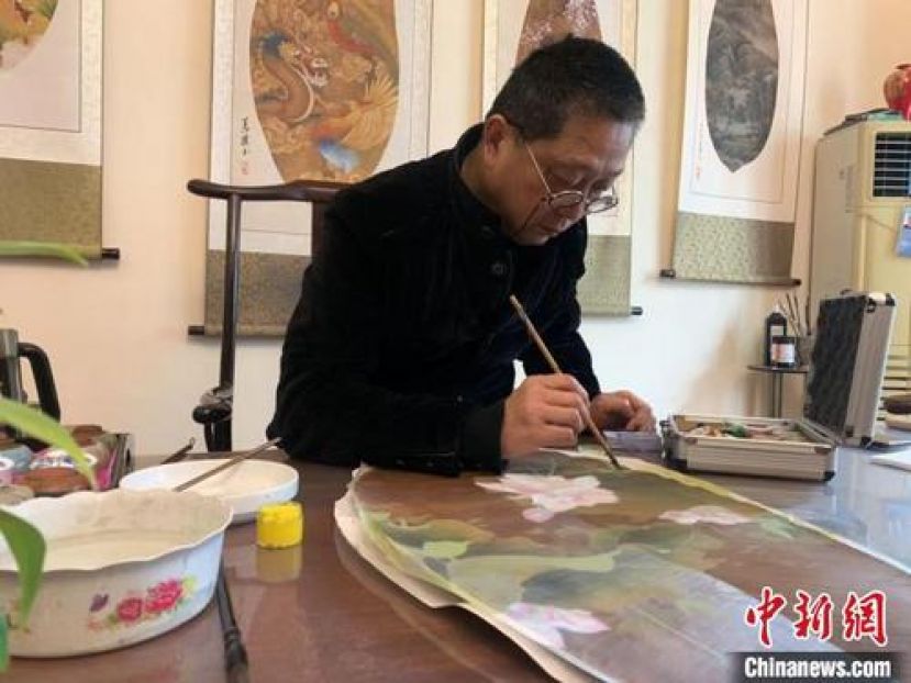 刘义桥正在绘制叶画。