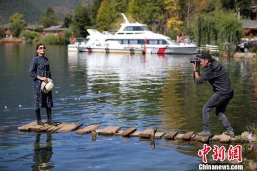 &ldquo;走山人&rdquo;给游客拍照。
